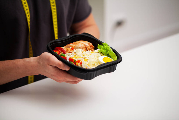 Detailní záběr muže držícího krabici plnou potravin bohatých na bílkoviny pro sportovní výživu. - Fotografie, Obrázek