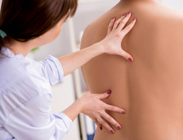 Молода жінка-лікар хіропрактик масажуючи пацієнта чоловічої статі
 - Фото, зображення