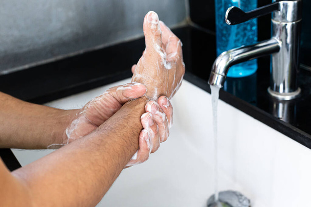 L'uomo si sta lavando le mani in un lavandino igienizzando il virus colona per la sanificazione e riducendo la diffusione del COVID-19 diffusione in tutto il mondo, Igiene, Concetto di igiene. - Foto, immagini