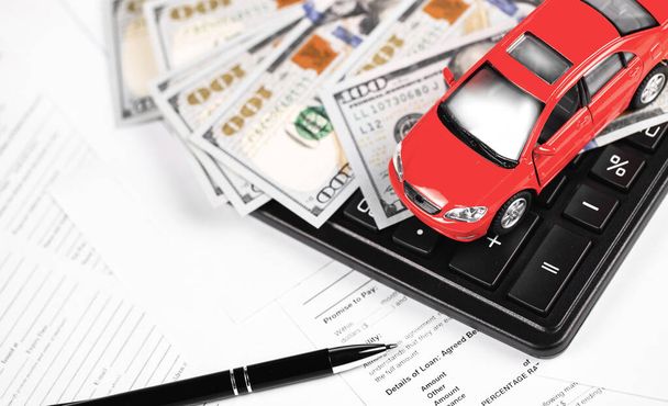 červené auto a kalkulačka s penězi, dolary bankovky detailně na papíře - Fotografie, Obrázek