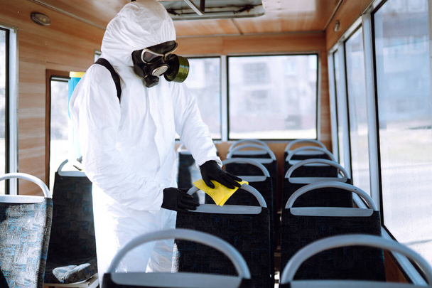 Hand of Man in protective suit washing and disinfection public transport, to preventing the spread of the epidemic of coronavirus, pandemic in quarantine city. Covid-19. - Valokuva, kuva