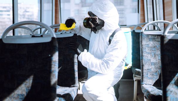 Hand of Man in protective suit washing and disinfection public transport, to preventing the spread of the epidemic of coronavirus, pandemic in quarantine city. Covid-19. - 写真・画像