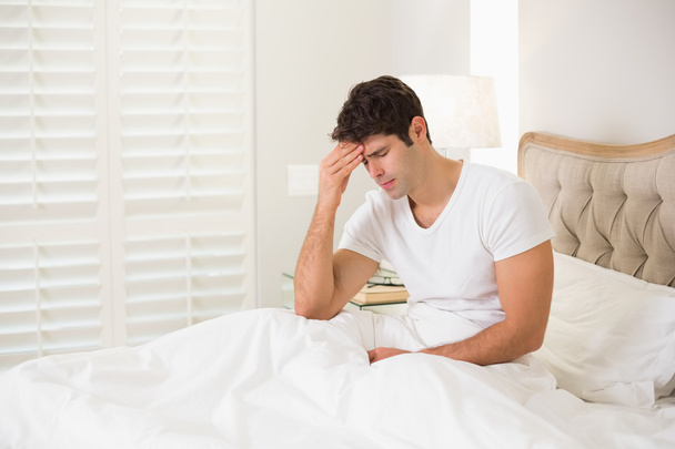 Young man suffering from headache in bed - Φωτογραφία, εικόνα