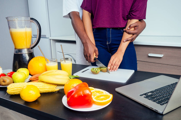 cropped shot of dark skinned couple making smoothies, pouring juice - Fotografie, Obrázek