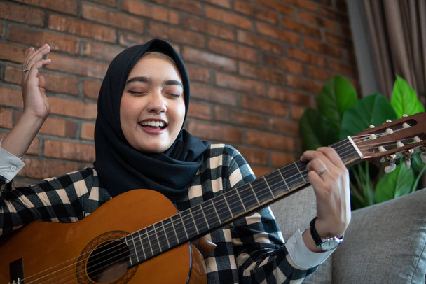 muslim woman play guitar - Foto, Bild