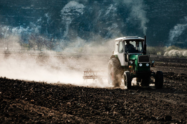 Farmář v traktoru připravuje půdu. Zemědělské práce na zemědělské půdě. zemědělské práce orání půdy na traktoru. Traktor na zemědělském poli v Moldavsku, Evropa. - Fotografie, Obrázek