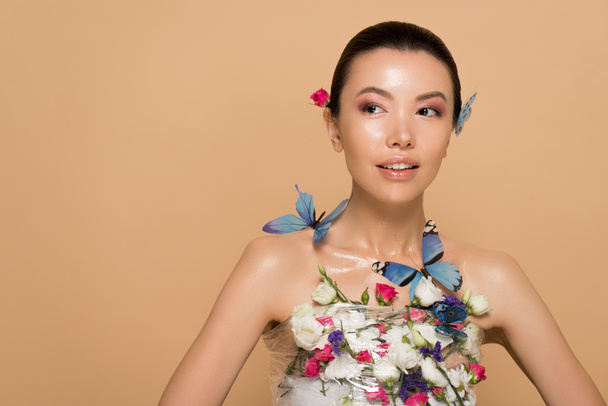 beautiful tender naked asian girl in flowers with butterflies on body isolated on beige - Foto, immagini