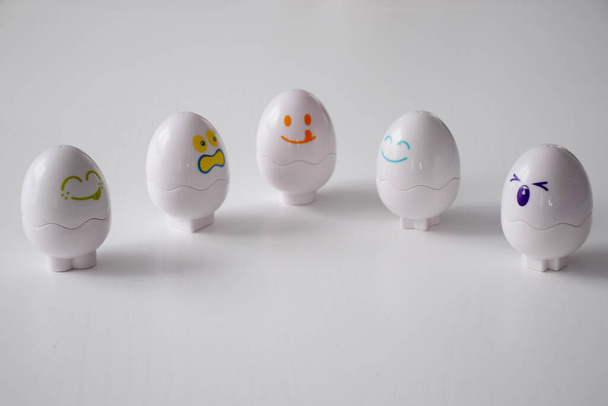 Αστεία συναισθηματικά αυγά στο λευκό τραπέζι - Φωτογραφία, εικόνα