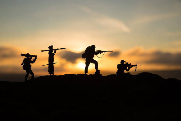 Militaire soldaten silhouetten met bazooka en rpg. Oorlogsconcept. Militaire silhouetten vechtscène op oorlog mist lucht achtergrond, Mojahed met rpg en ons soldaat met bazooka bij zonsondergang. Aanvalsscène - Foto, afbeelding