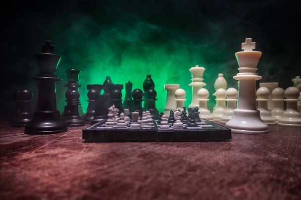 Schachbrettspiel Konzept von Geschäftsideen und Wettbewerb. Schachfiguren auf dunklem Hintergrund mit Rauch und Nebel. Selektiver Fokus - Foto, Bild
