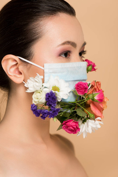 attractive naked asian woman in floral face mask isolated on beige - Zdjęcie, obraz