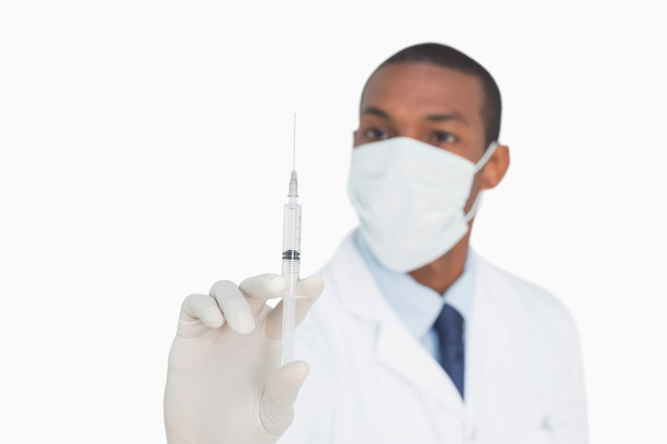 Male doctor in mask and glove holding an injection - Foto, imagen