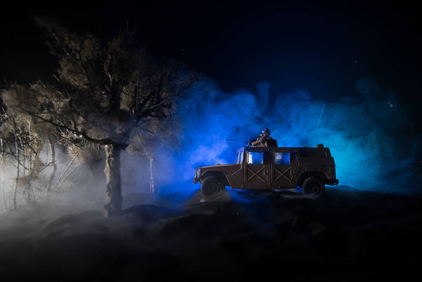 Oorlogsconcept. Strijd scène op oorlog mist lucht achtergrond, Vecht silhouetten Onder bewolkt Skyline 's nachts. Legervoertuig met soldaten kunstwerk decoratie. Selectieve focus - Foto, afbeelding