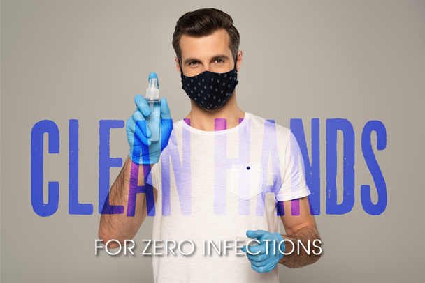 Mann mit Latex-Handschuhen und Schutzmaske hält Händedesinfektionsmittel isoliert auf grauen, sauberen Händen für null Infektionen Illustration  - Foto, Bild