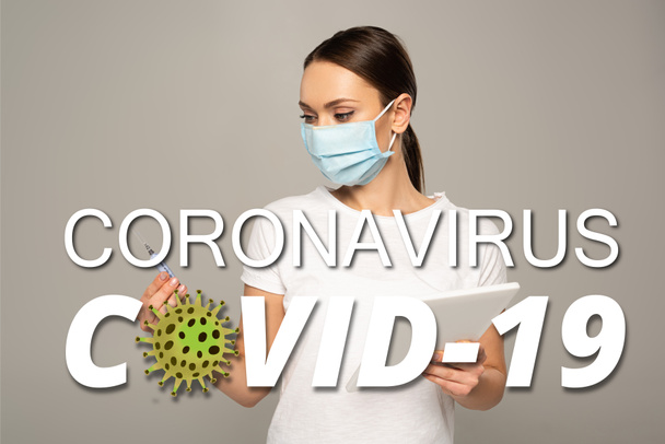 Menina em máscara médica segurando seringa e comprimido digital isolado em cinza, coronavírus covid-19 ilustração
 - Foto, Imagem