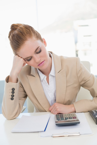 Worried businesswoman sitting at office desk - Фото, изображение