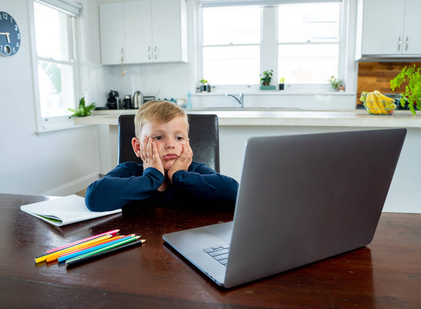 Coronavirus Outbreak. Lockdown and school closures. School boy with face mask watching online education classes feeling bored and depressed at home. COVID-19 pandemic forces children online learning. - Valokuva, kuva