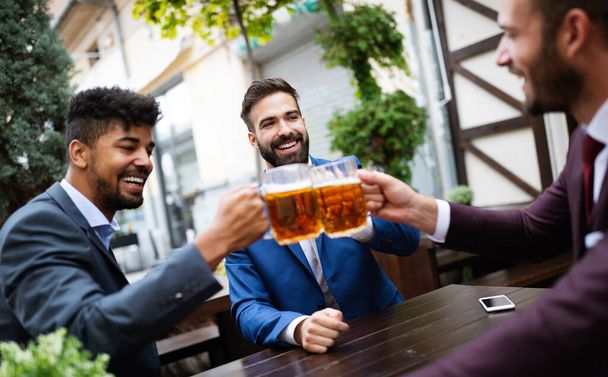 Cheerful old friends, business man having fun and drinking beer at bar counter in pub. - Φωτογραφία, εικόνα