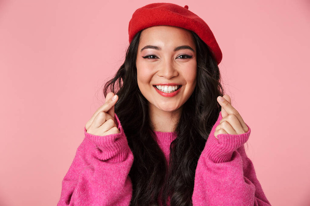 Image of happy beautiful asian girl showing money counting gesture with fingers isolated over pink background - Foto, immagini