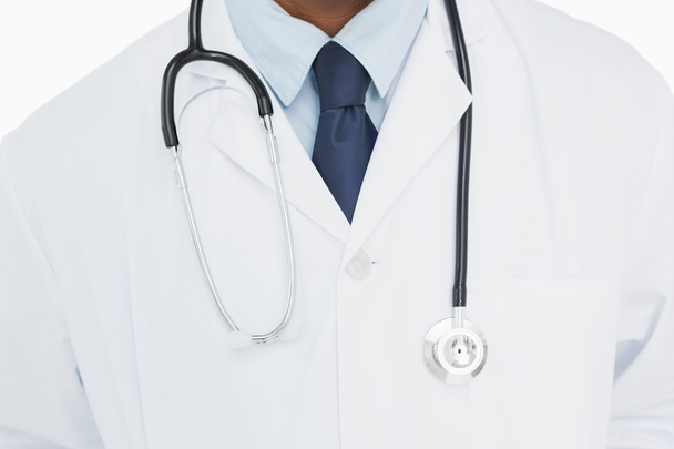 Mid section of a male doctor in lab coat and with stethoscope - Foto, immagini