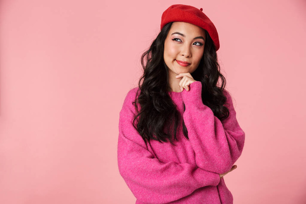 Image of young beautiful asian girl with long dark hair wearing beret thinking or dreaming isolated over pink background - Φωτογραφία, εικόνα