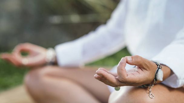 Kadın meditasyon yapıyor, enerjiyi dengeliyor. Eller mudra pozisyonunda. - Fotoğraf, Görsel