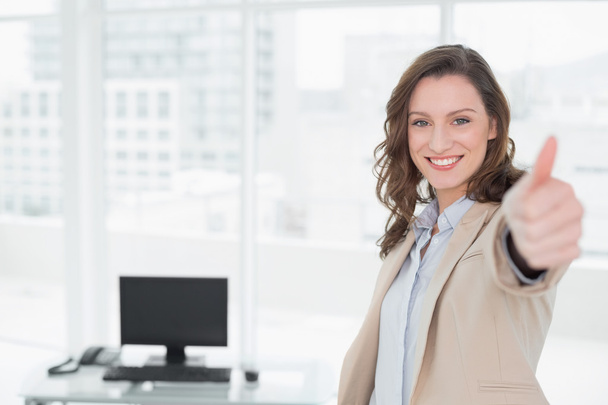 Elegant smiling businesswoman gesturing thumbs up in office - Zdjęcie, obraz