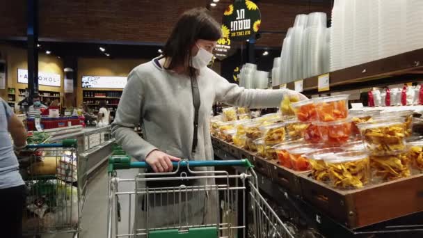 ISRAEL - Netanya, 14 March 2020: Buyer wearing a protective mask. Shopping during a pandemic. Emergency to buy a list. Panic purchase during an outbreak of coronavirus. Pandemic Quarantine Preparation - Кадры, видео