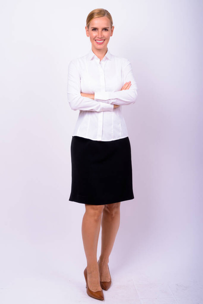 Studio shot of beautiful blonde businesswoman against white background - Фото, изображение