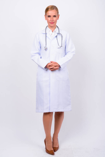Studioaufnahme der schönen blonden Ärztin vor weißem Hintergrund - Foto, Bild