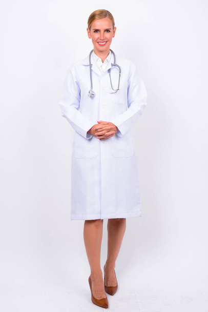Studioaufnahme der schönen blonden Ärztin vor weißem Hintergrund - Foto, Bild
