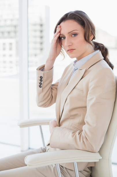 Portrait of businesswoman suffering from headache in office - Foto, imagen