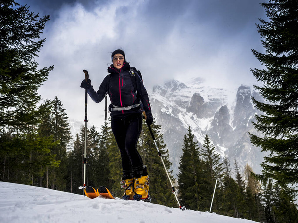jonge skiër klimt naar de top van de berg. - Foto, afbeelding