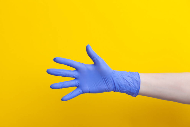 Doctor hand in medical lilac rubber glove showing palm, five fingers - 写真・画像