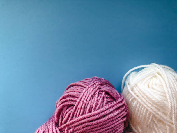 Skeins avec des fils pour tricoter sur un fond de couleur bleu couleur classique de l'année. Modèle de broderie à l'aiguille
. - Photo, image