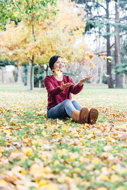 Felice autunno donna giocando in foglie
 - Foto, immagini