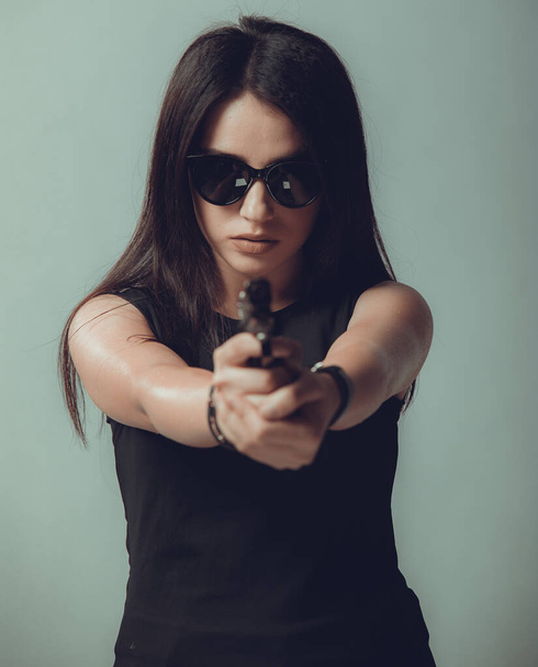 Shot of a sexy military woman posing with guns,black glasses in the eyes, - Fotó, kép