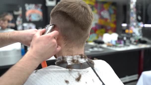 Male haircut with electric razor. Close up of hair trimmer hairstyle. Barber makes haircut for client at the barber shop by using hairclipper. Man hairdressing with electric shaver. Slow motion shot. - Footage, Video