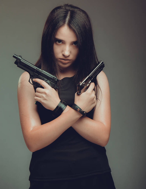 Shot of a sexy military woman posing with guns, - Фото, изображение