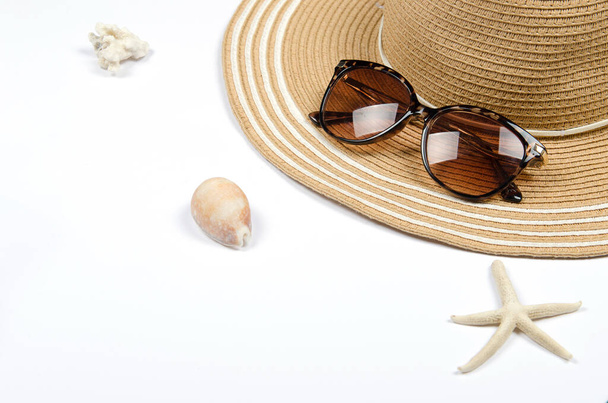 Summer straw hat, sunglasses, shells, starfish on white background. - Photo, Image