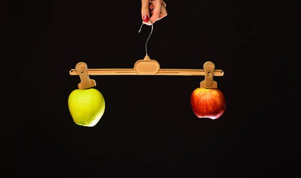 Female hand holds hanger with fruits on tips - Foto, Imagen