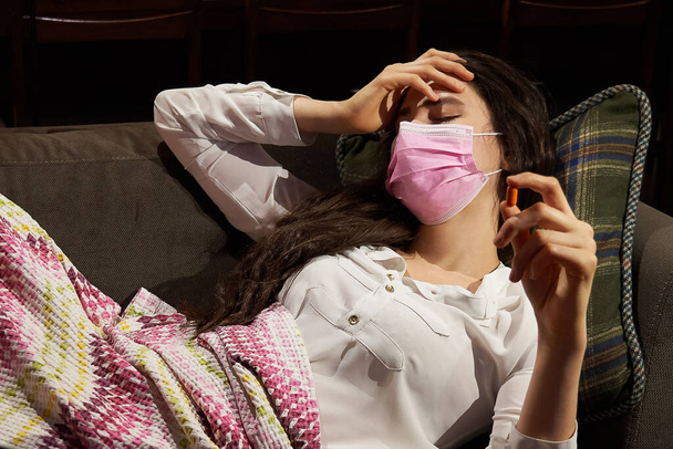 jeune femme sur le canapé recouvert d'une couverture gelée soufflant du nez a eu de la fièvre, attrapé, fille malade ayant des symptômes de la grippe, la grippe ou concept de virus
 - Photo, image