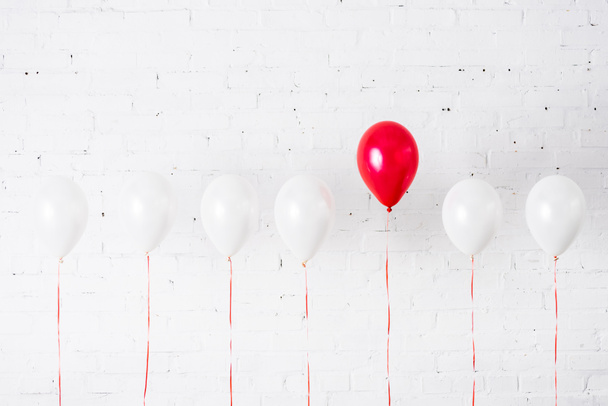 Unieke rode ballon onder elkaar op witte achtergrond - Foto, afbeelding