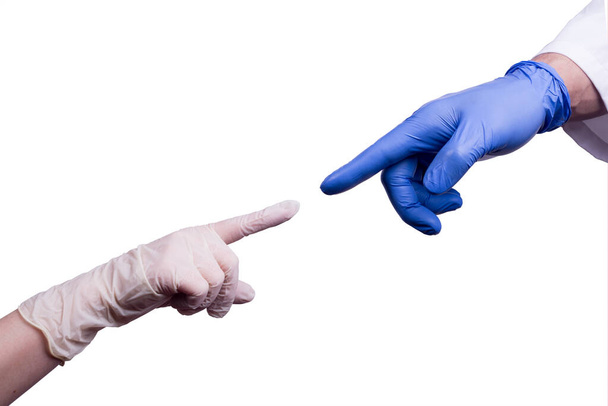 Steril gumikesztyűt viselő kezek egymás felé nyúlnak. Orvosok és ápoló kezek elszigetelve fehér háttérrel. A koronavírus-karantén időtartama. - Fotó, kép