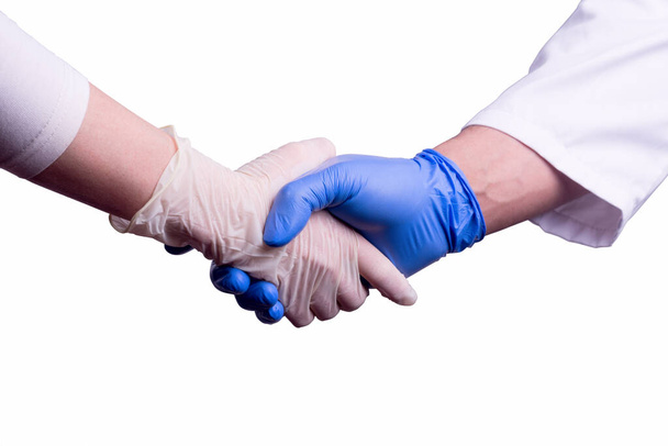 Uścisk dłoni między lekarzem a pielęgniarką w sterylnych rękawiczkach lateksowych wyizolowanych na białym tle. Koncepcja czasu kwarantanny koronawirusu - Zdjęcie, obraz