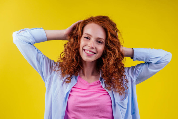 happy redhead ginger curly woman feeling good emotions in studio shot yellow background. language education idea - Foto, Imagen