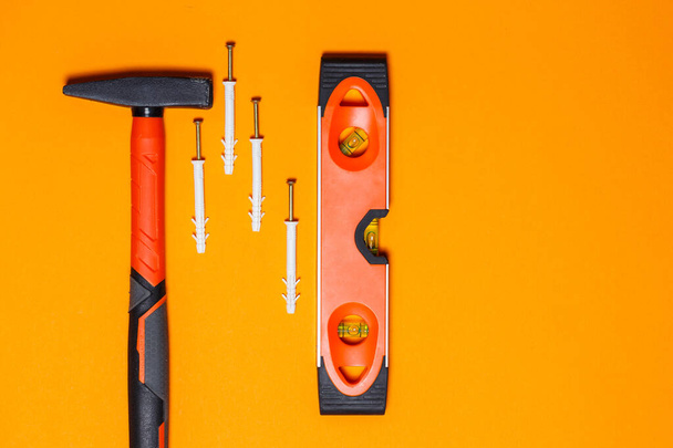 Tamir için aletler. Çivi için çekiç, kat, portakal rengi arka planda duvar pervazı. Sihirbaz için araç takımı - Fotoğraf, Görsel