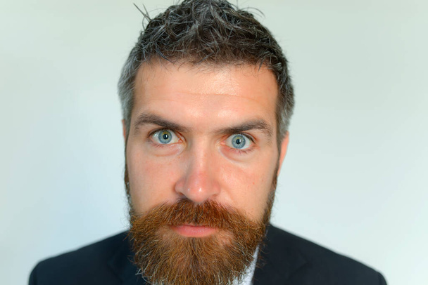Man with thick beard and blue eyes on grey background - Foto, afbeelding
