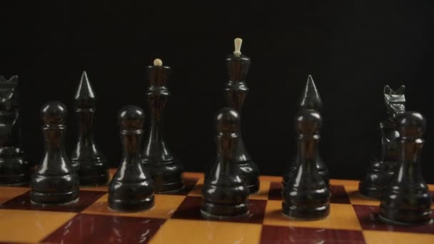 Breite Aufnahme schwarzer Holzschachfiguren auf einem Schachbrett in der Ausgangsposition - Filmmaterial, Video