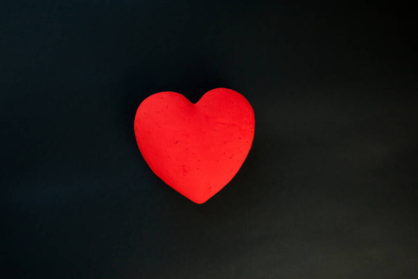 Coeur de gypse rouge unique sur fond de velours noir
 - Photo, image